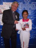 A pupil from one of our national schools who features in "Moving On" receives a copy of the book from Rev Canon John McCullagh