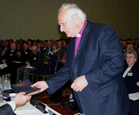 Archbishop Robin Eames lays the new Book of Common Prayer on the table